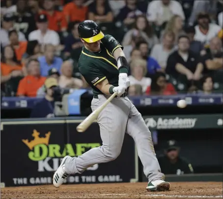  ?? DAVID J. PHILLIP — THE ASSOCIATED PRESS ?? Sean Murphy hits a two-run home run for Oakland during the fourth inning of Monday’s blowout victory in Houston.