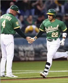  ?? BEN MARGOT – THE ASSOCIATED PRESS ?? The A’s Ramon Laureano, right, is congratula­ted by third base coach Matt Williams after hitting a home run off Texas Rangers pitcher Yovani Gallardo in the first inning of Friday’s game at the Coliseum.