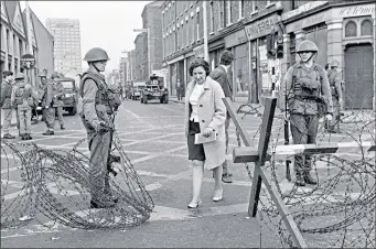  ??  ?? Soldiers allow a woman to pass through a road block in Divis Street, Belfast in 1969