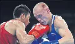  ?? AFP ?? Thailand’s Chatchai Butdee, left, fights against Russia’s Vladimir Nikitin.