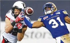  ?? Canadian Press photo ?? Winnipeg Blue Bombers’ Brandon Alexander (21) intercepts the pass intended for Ottawa Redblacks’ Greg Ellingson (82) during the second half of CFL action in Winnipeg Friday.