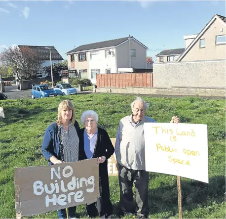  ??  ?? Residents Laura Black, 57, Elizabeth Wright, 83, and James Smith, 84, with their protest signs on the land.