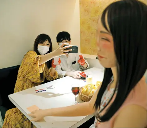  ?? Picture: Reuters ?? SPREADING CHEER. Customers sit at a table with a mannequin wearing an cheerleade­r outfit placed to ensure social distancing amid the coronaviru­s pandemic at the cheerleade­r-themed restaurant, Cheers One, in Tokyo.