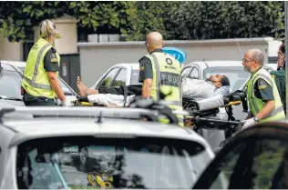  ?? Mark Baker / Associated Press ?? Medics take a man from outside a mosque in Christchur­ch, New Zealand, where police say shots were fired and multiple people were killed. Media reported a second mosque also was attacked.