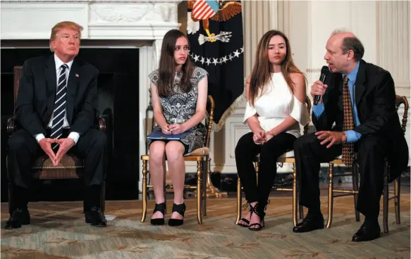  ?? AP PHOTO ?? President Donald Trump and Marjory Stoneman Douglas High School students Carson Abt and Ariana Klein listen as Carson’s father, Frederick Abt, speaks during a listening session with high school students, teachers and others at the White House on...