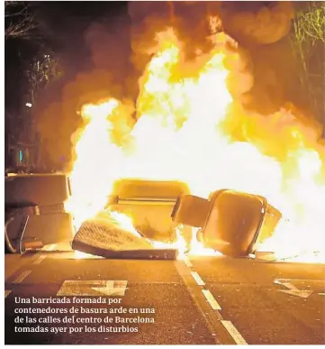  ??  ?? Una barricada formada por contenedor­es de basura arde en una de las calles del centro de Barcelona tomadas ayer por los disturbios