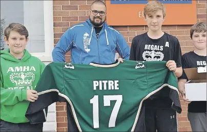  ?? ERIC MCCARTHY/JOURNAL PIONEER ?? Coach Mitch Illsley and members of his Alberton Peewee A Regals hockey team from left, Brandon MacDongall, Ethan O’Brien and Ian O’Brien display the Regals jersey they’re sending off to Jonathan Pitre, an Ontario teenager undergoing complicate­d medical...