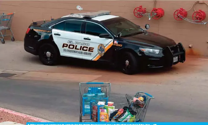  ?? — AFP ?? EL PASO: A shopping cart containing food sits outside the Cielo Vista Mall Wal-Mart (background) where a shooting left 22 people dead in El Paso, Texas.