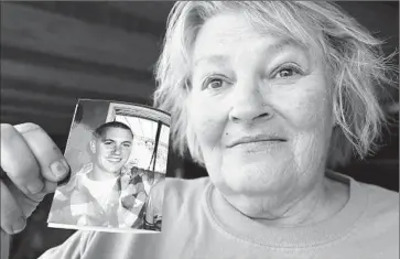  ?? Robert Gauthier
Los Angeles Times ?? ANNE CLEMENSON holds a picture of her son Francis Pusok, who was beaten by deputies. “I’ve always thought that police are to serve and protect, and what they did ... it was not called for,” she said.