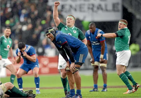 ?? PHOTO: AP ?? Irish players celebrate as French players despair after Johnny Sexton’s late dropped goal gave Ireland a dramatic victory in Paris.