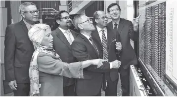  ??  ?? Muhamad Fuad (fourth left), Wan Azman (second right) and other directors from Gagasan Nadi looking on at the stock performanc­e display after the group’s listing on the Main Market of Bursa Malaysia yesterday. — Bernama photo