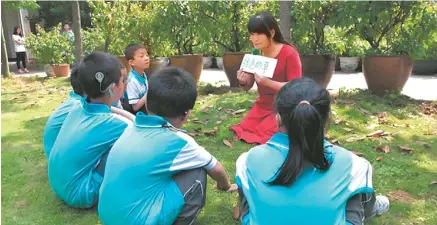  ?? China Daily ?? Liu Lingli teaches children who are deaf or hard of hearing in an outdoor class.