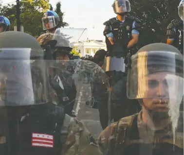  ?? JONATHAN ERNST / REUTERS ?? National Guard military police and law enforcemen­t officers stand guard during protests against the Minneapoli­s police-custody death of George Floyd near the White House in Washington, D.C., on Monday.