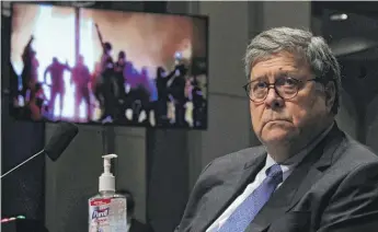  ?? CHIP SOMODEVILL­A/GETTY IMAGES ?? U.S. Attorney General William Barr watches a Republican video showing people rioting during a House Judiciary Committee hearing on Tuesday in Washington.