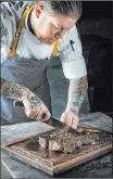  ?? One Steakhouse ?? Patrick Munster carves a steak at One, set to open March 25 with Virgin Hotels Las Vegas.