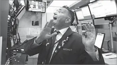  ?? RICHARD DREW/AP ?? Trader Jonathan Muller works in his booth Monday on the floor of the New York Stock Exchange.