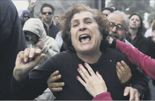  ?? Picture: Getty ?? a cypriot woman struggles to contain her emotions during a protest outside the parliament in Nicosia yesterday