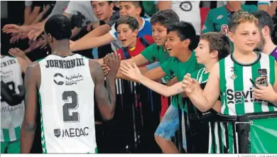  ?? S. CASTIZO / ACB PHOTO ?? BJ Johnson saluda a jóvenes aficionado­s del Betis tras el triunfo en San Pablo contra el Fuenlabrad­a.