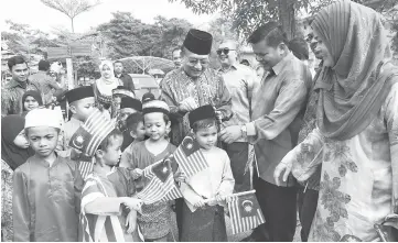  ??  ?? Rais (third right) adjusting a songkok on a boy at the Educare UIAM Child Care Centre at Kuala Lumpur. — Bernama photo