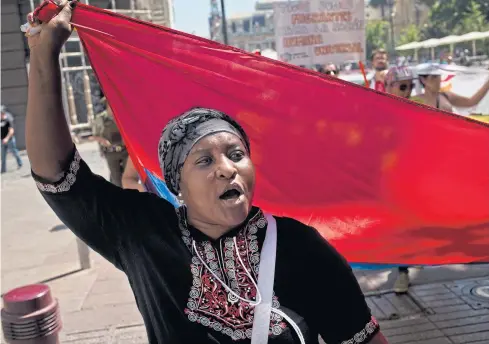  ?? AP ?? A Colombian woman protests against Chile’s visa fee increase during a demonstrat­ion in Santiago. Restrictio­ns on immigratio­n in Chile can help explain the dearth of entreprene­urship, innovation, and diversific­ation.