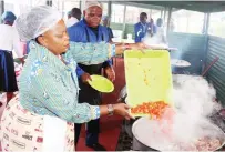  ?? ?? First Lady Dr Auxillia Mnangagwa prepares a meal for children living and working on the streets at the skills developmen­t centre in Mbare yesterday