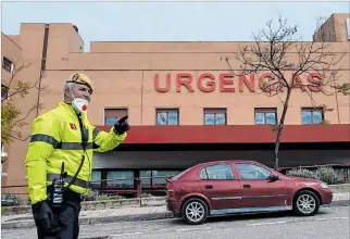  ?? EL PAÍS ?? España. Un miembro de la Unidad Militar de Emergencia­s ante la puerta del hospital San Juan de Dios.