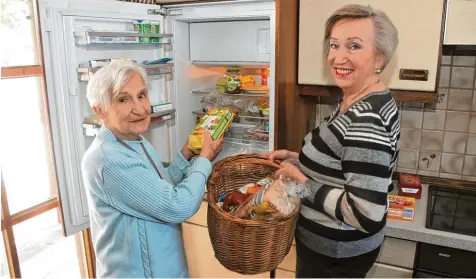  ?? Foto: Andreas Lode ?? In Diedorf läuft die Nachbarsch­aftshilfe gut. Ingrid Endreß (rechts) hat für ihre Nachbarin Walburga Eismann die Einkäufe erledigt, zusammen füllen sie die Vorräte im Kühl schrank auf.