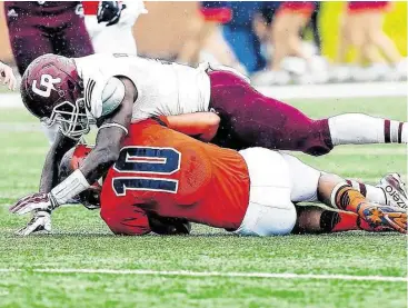  ?? Diana L. Porter / For the Chronicle ?? Seven Lakes quarterbac­k Cameron Thomas is sacked in the backfield by Cinco Ranch’s Dami Ilesanmi during the Cougars’ win last weekend.