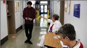  ?? Brian Porter / The Fort Morgan Times ?? Morgan County Election judge Sharon Bishop assists a voter with in-person Election Day voting for the 2022 Primary Election. Also shown is Gertie Chapin in the foreground.