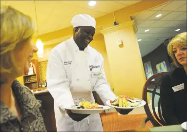  ?? Brian A. Pounds / Hearst Connecticu­t Media ?? Executive Chef Michael Stevens shows examples of a Thrive Dining chef salad next to a traditiona­l chef salad to Sales Director Ann Serti, left, and Executive Director Kristin Butler at The Watermark at 3030 Park in Bridgeport in 2016.