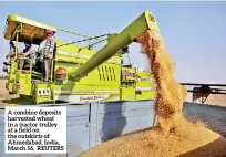  ?? ?? A combine deposits harvested wheat in a tractor trolley at a field on the outskirts of Ahmedabad, India, March 16, REUTERS