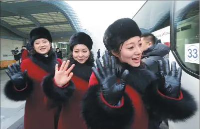  ?? AHN YOUNG-JOON / REUTERS ?? DPRK cheering squads wave after arriving at the Korean transit office near the Demilitari­zed Zone in Paju, the ROK, on Wednesday.