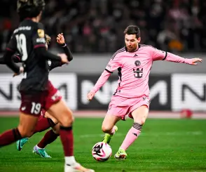  ?? — AFP photo ?? Inter Miami’s forward Messi (right) kicks the ball during the second half of the friendly match against Vissel Kobe of Japan’s J-League at the National Stadium in Tokyo.