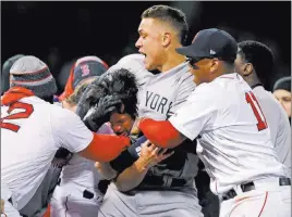  ?? Charles Krupa ?? The Associated Press New York’s Aaron Judge puts Boston relief pitcher Joe Kelly in a headlock after Kelly hit Tyler Austin with a pitch in the seventh inning of the Yankees’ 10-7 win Wednesday.