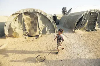  ??  ?? An internally displaced Syrian boy plays with a wheel in Jrzinaz Camp in the southern part of Idlib, Syria, June 21, 2016.