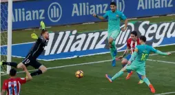  ?? — AP ?? Lionel Messi (right) scores the winner against Atletico de Madrid on Sunday.