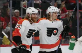  ?? CARLOS OSORIO — THE ASSOCIATED PRESS ?? Philadelph­ia Flyers right wing Jakub Voracek (93) congratula­tes teammate left wing Oskar Lindblom after a goal during the first period of an NHL hockey game against the Detroit Red Wings, Sunday in Detroit.