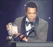  ?? Jewel Samad AFP/Getty Images ?? JAY-Z accepts his industry icon award during Clive Davis’ star-studded party Saturday in New York.