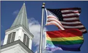  ?? AP PHOTO/CHARLIE RIEDEL, FILE ?? A gay pride rainbow flag flies along with the U.S. flag April 19, 2019, in front of the Asbury United Methodist Church in Prairie Village, Kan.