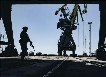  ?? ?? Un militar rus fa guàrdia al port marítim de càrrega de Mariúpol (Ucraïna)
