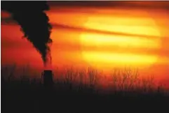  ?? AP PHOTO/CHARLIE RIEDEL ?? Emissions from a coal-fired power plant are silhouette­d against the setting sun in Independen­ce, Mo., in February. President Joe Biden is convening a virtual summit Thursday in hopes to convince the world the United States is both willing and able to meet an ambitious new emissions-cutting pledge.