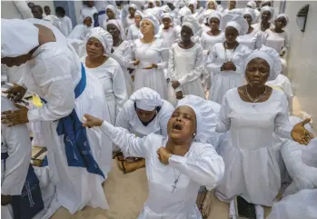  ?? BEN CURTIS/AP ?? Prayers for the nation: Members of the congregati­on at the Celestial Church of Christ Olowu Cathedral sing and chant during a Friday service on Lagos Island in Nigeria in which they prayed for the country and against the forces of evil ahead of national elections. Voters go to the polls Saturday to select a new president to succeed President Muhammadu Buhari.