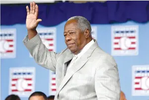  ?? The Associated Press ?? Q Hall of Famer Hank Aaron waves to the crowd during Baseball Hall of Fame induction ceremonies July 28, 2013, in Cooperstow­n, N.Y. Hank Aaron, who endured racist threats with stoic dignity during his pursuit of Babe Ruth but went on to break the career home run record in the pre-steroids era, died early Friday. He was 86. The Atlanta Braves said Aaron died peacefully in his sleep. No cause of death was given.