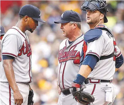  ?? JUSTIN K. ALLER/GETTY IMAGES 2015 ?? New Orioles pitching coach Roger McDowell, center, during a Braves mound visit, said he learned everything he knows about being a pitching coach from his predecesso­r with the Orioles, Dave Wallace. McDowell pitched for the Orioles in 1996.