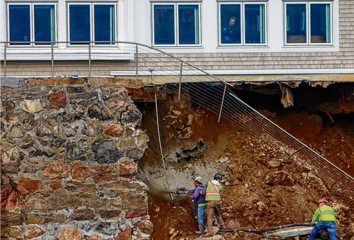  ?? MATTHEW J. LEE/GLOBE STAFF ?? Workers sprayed cement in an effort to shore up the seawall that collapsed under the Mission on the Bay restaurant in Swampscott on Thursday.