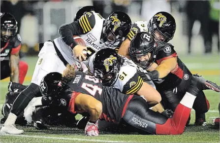  ?? SEAN KILPATRICK THE CANADIAN PRESS ?? Hamilton Tiger-Cats defensive back Khalid Wooten, top left, runs the ball while taking on the Ottawa Redblacks during first-half action in Ottawa.