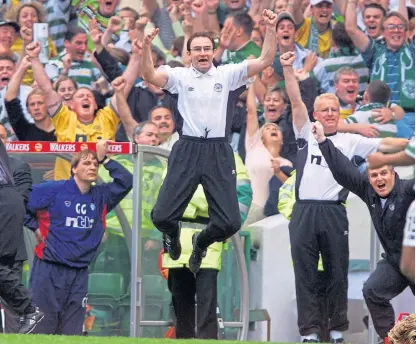  ?? ?? Martin O’Neill leaps with joy as his side consign Rangers to a 6-2 defeat at Celtic Park in his first Old Firm game in charge of the Hoops