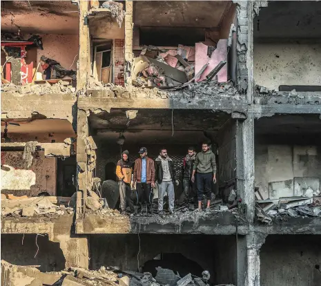  ?? Getty Images, AFP ?? Top, a self-propelled field gun used by the Israeli army in Southern Israel; above, Palestinia­ns in a building destroyed by Israeli air strikes in Rafah, in the southern Gaza Strip