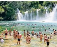  ??  ?? Unterhalb der Wasserfäll­e im Krka Nationalpa­rk in Südkroatie­n baden gerne Touristen.