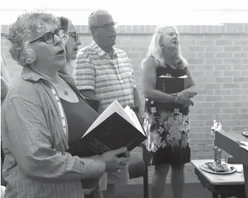  ?? Kelsey Walling photos/The Galveston County Daily News via AP ?? leftCongre­gation B’nai Israel member Sara Salzman sings a Hebrew prayer with other members July 6 during Rabbi Marshal Klaven’s last Shabbat service in Galveston. A Shabbat service includes many songs and prayers in Hebrew and English.